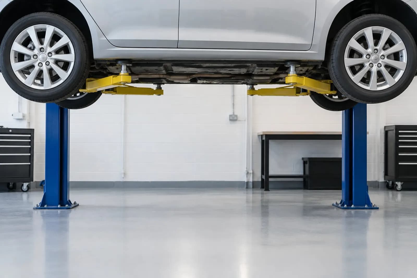 A car raised on a ramp for an underside inspection